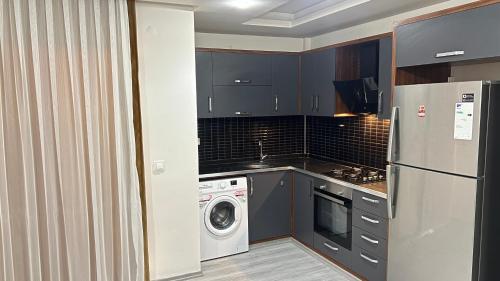 a kitchen with a refrigerator and a washing machine at Aljari otel in Mezitli