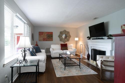 a living room with a white couch and a fireplace at Private Jacksonville Getaway Near San Marco Square in Jacksonville
