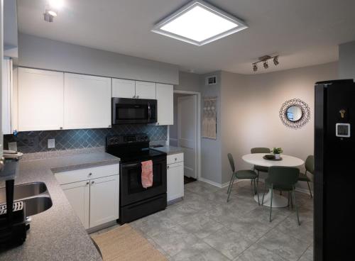 a kitchen with white cabinets and a table with chairs at Private Jacksonville Getaway Near San Marco Square in Jacksonville