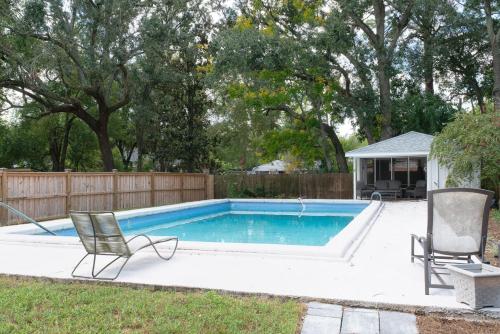 a swimming pool with two chairs and a fence at Private Jacksonville Getaway Near San Marco Square in Jacksonville
