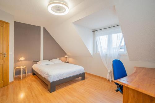 a bedroom with a bed and a desk and a window at Ma Vie'La - Swimming Pool - Balneo - Jacuzzi - Sauna in Rhinau