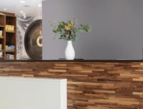 een vaas met bloemen op een toonbank bij Hampton Inn & Suites Cadillac in Cadillac