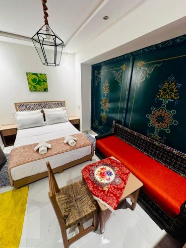 ein Schlafzimmer mit zwei Betten und einer roten Bank in der Unterkunft Riad hotel Cecil in Marrakesch