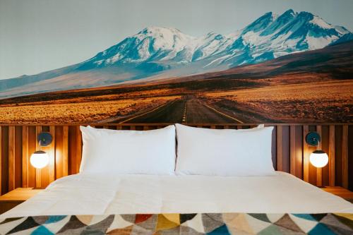 a bed with a mountain mural on the wall at La Vista Motel in Denver