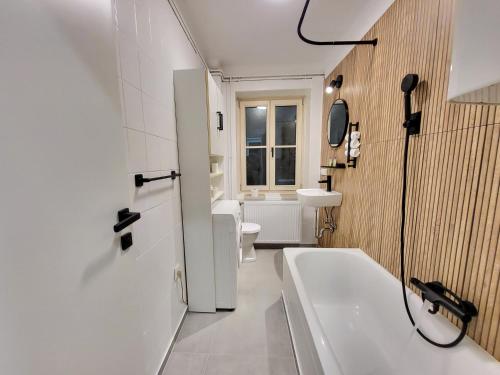 a bathroom with a tub and a toilet and a sink at Stilvoll renoviertes 50m2 Apartment in Grünlage - ganze Unterkunft in Graz