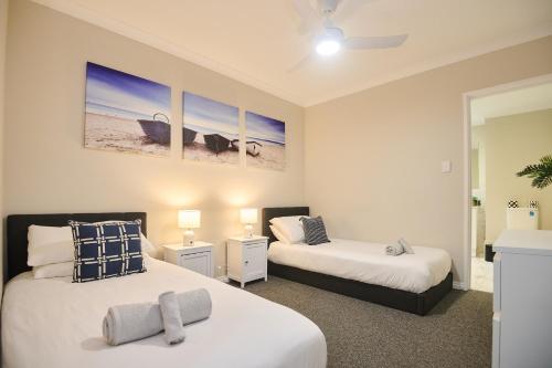 a bedroom with two beds and two tables with lamps at Central Perth Apartment with Pool in Perth