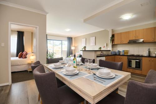 a kitchen and dining room with a table and chairs at Central Perth Apartment with Pool in Perth