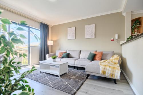 a living room with a couch and a table at Central Perth Apartment with Pool in Perth