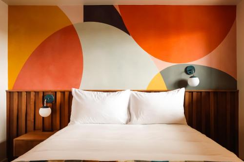 a bedroom with a bed with a colorful wall at La Vista Motel in Denver