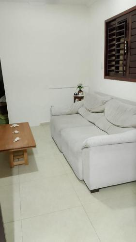 a white room with a bed and a table at Casa grande e aconchegante, muito central, aluguel de quartos in Natal