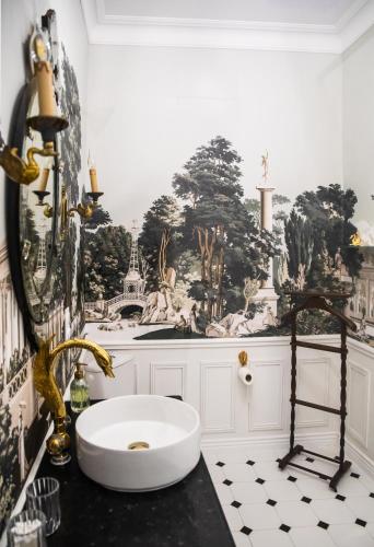 a bathroom with a black and white tile floor and a sink at Maison la Louise in Ligny-en-Barrois