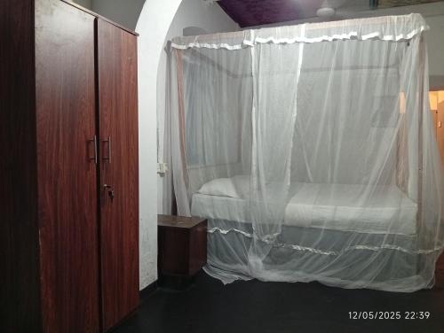 a bedroom with a bed with a mosquito net at Grandma's House Villa in Weligama