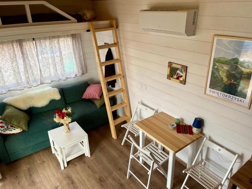 a living room with a couch and a table and a ladder at Jemiołucha Glamp in Bodzentyn