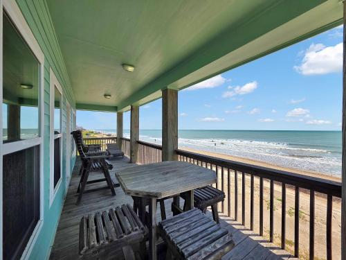 veranda con tavolo e sedie sulla spiaggia di Sea Mist a Gilchrist