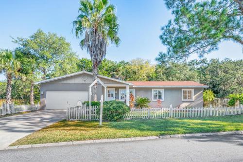 a house with a white fence and a palm tree at Marsh Front Birders Paradise Close to Beaches and Downtown in St. Augustine
