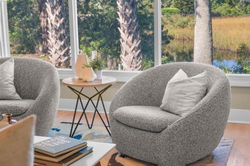 two chairs in a living room with a table at Marsh Front Birders Paradise Close to Beaches and Downtown in St. Augustine