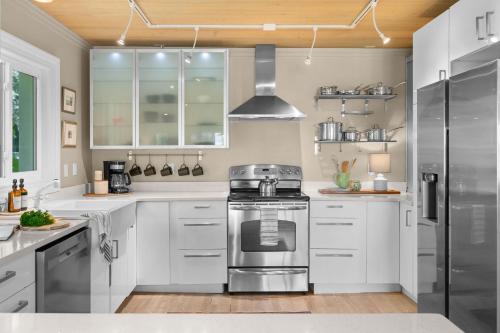 a kitchen with white cabinets and stainless steel appliances at Marsh Front Birders Paradise Close to Beaches and Downtown in St. Augustine
