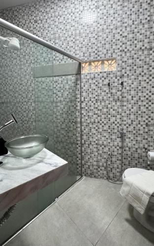 a bathroom with a sink and a toilet in it at Casa Maroka in Japaratinga