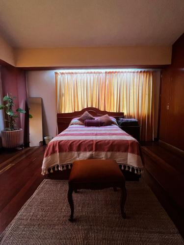 a bedroom with a large bed with a window at Casa Carmesí in Oaxaca City