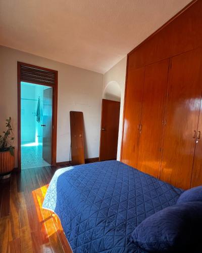 a bedroom with a blue bed and wooden cabinets at Casa Carmesí in Oaxaca City