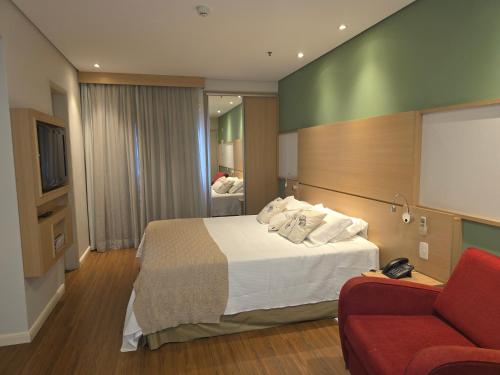 a hotel room with a bed and a couch at Mercure Nações Unidas - Apto 910 in Sao Paulo