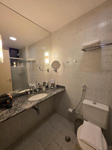 a bathroom with a toilet and a sink and a mirror at Mercure Nações Unidas - Apto 910 in Sao Paulo