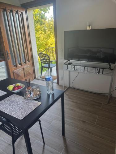 ein Wohnzimmer mit einem Tisch und einer Glastür in der Unterkunft Studio indépendant in Divonne-les-Bains