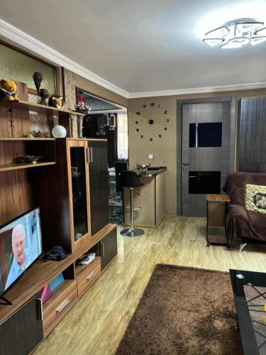 a living room with a couch and a television at Dachi Apartment in Sighnaghi