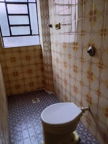 Hotel Flamingo's في سانتوس: حمام به مرحاض وجدار من البلاط