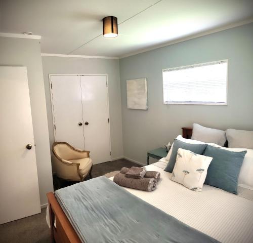 een slaapkamer met een bed met een stoel en een raam bij Hydrangea Cottage in Marton in Marton