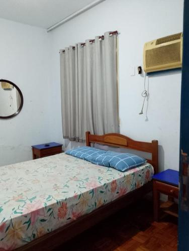 Hotel Flamingo's في سانتوس: غرفة نوم صغيرة بها سرير ونافذة