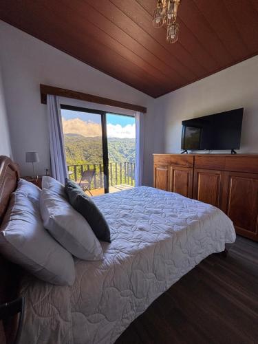 La Casa Bonita في مونتيفيردي كوستاريكا: غرفة نوم بها سرير ونافذة كبيرة