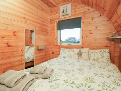 a bedroom with a bed in a wooden cabin at Rowan in Ulverston