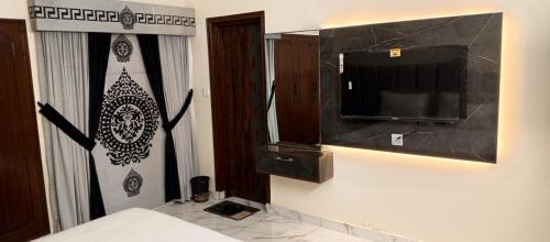 a bedroom with a tv and a bed in a room at Royal Continental DHA Karachi in Karachi