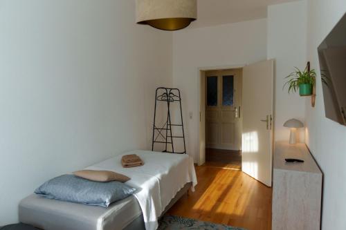 a white room with a bed and a table at Gemütliche 2-Raum-Wohnung in Leipzig