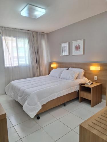 Suíte Confortável no Rio2 - Barra Olímpica RJ في ريو دي جانيرو: غرفة نوم بها سرير كبير وطاولة