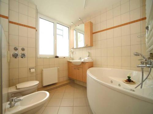 a bathroom with a tub and a toilet and a sink at Elegant eingerichtete Ferienwohnung in Granzow