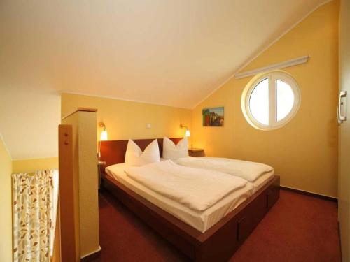 a bedroom with a large bed with a window at Elegant eingerichtete Ferienwohnung in Granzow
