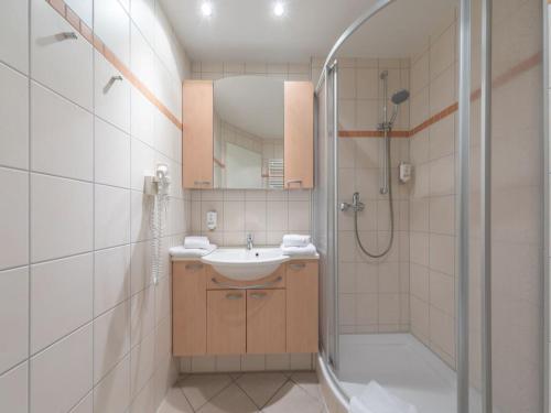 a bathroom with a sink and a shower at Ferienwohnung im Aparthotel Seepanorama in Granzow