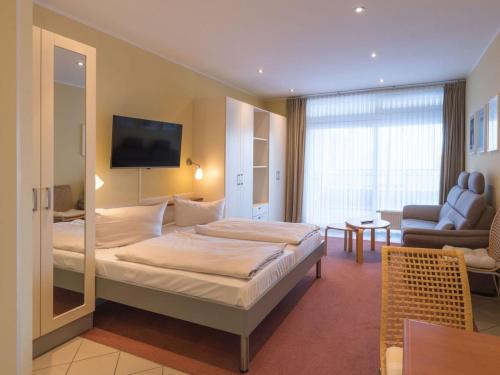 a hotel room with a bed and a living room at Ferienwohnung im Aparthotel Seepanorama in Granzow