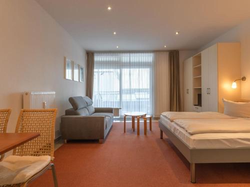 a hotel room with a bed and a couch at Ferienwohnung im Aparthotel Seepanorama in Granzow