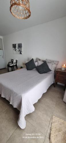 a large white bed in a bedroom with a chandelier at La Nona Nidia in Paraná