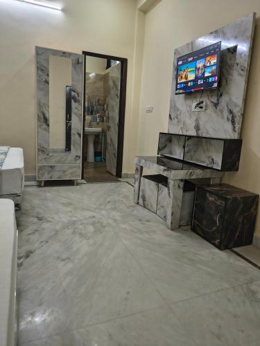 a bathroom with a tv on a marble wall at Bhagirathi Residency in Rishīkesh