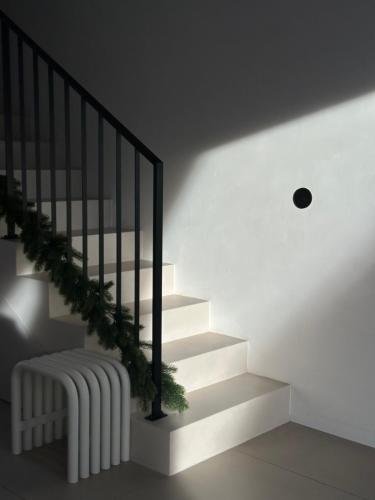 a stairway with a white stair case with a plant at Górski Domek Zakopane in Kościelisko