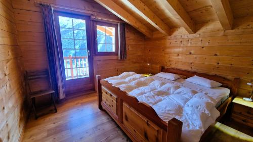 a bedroom with a large bed in a log cabin at Chalet La Giete 6 personnes La Forclaz in Haudères