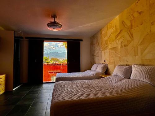a room with two beds and a large window at LA ESTANCIA, Casa EA Oaxaca, Centro Histórico, Balcón a las Montañas in Oaxaca City