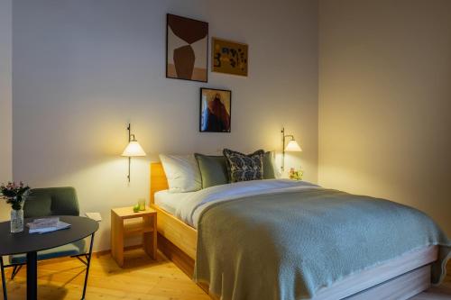 a bedroom with a bed and a table and a chair at La Senda Smart Hotel Zuoz in Zuoz