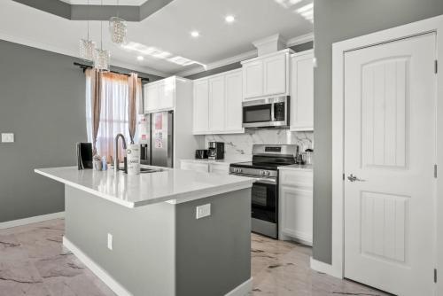 Casa San Juan Jr. في ميناء أرانساس: مطبخ بخزائن بيضاء وطاولة عمل