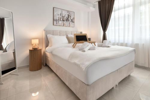 a bedroom with a large white bed with a laptop on it at Estia Premium Apartments - Superior Suite Vackhou 1 in Thessaloniki