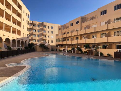 ein großes Schwimmbad vor einem Gebäude in der Unterkunft Apartamento con vista frontal al mar in El Médano